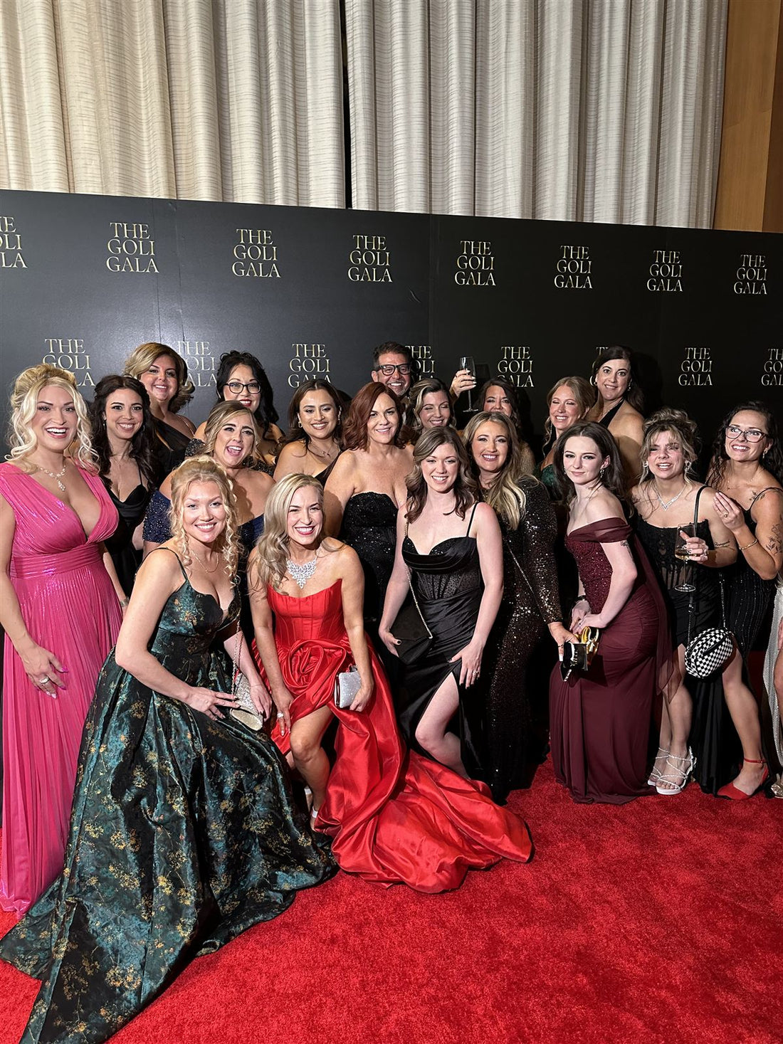 Creators and partners in formal gowns on the red carpet in front of THE GOLI GALA backdrop